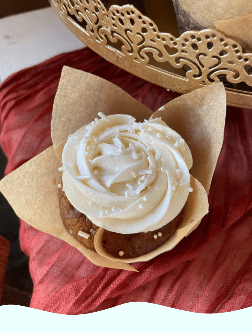 an elegant gluten free cupcake topped with white frosting and editable white pearls